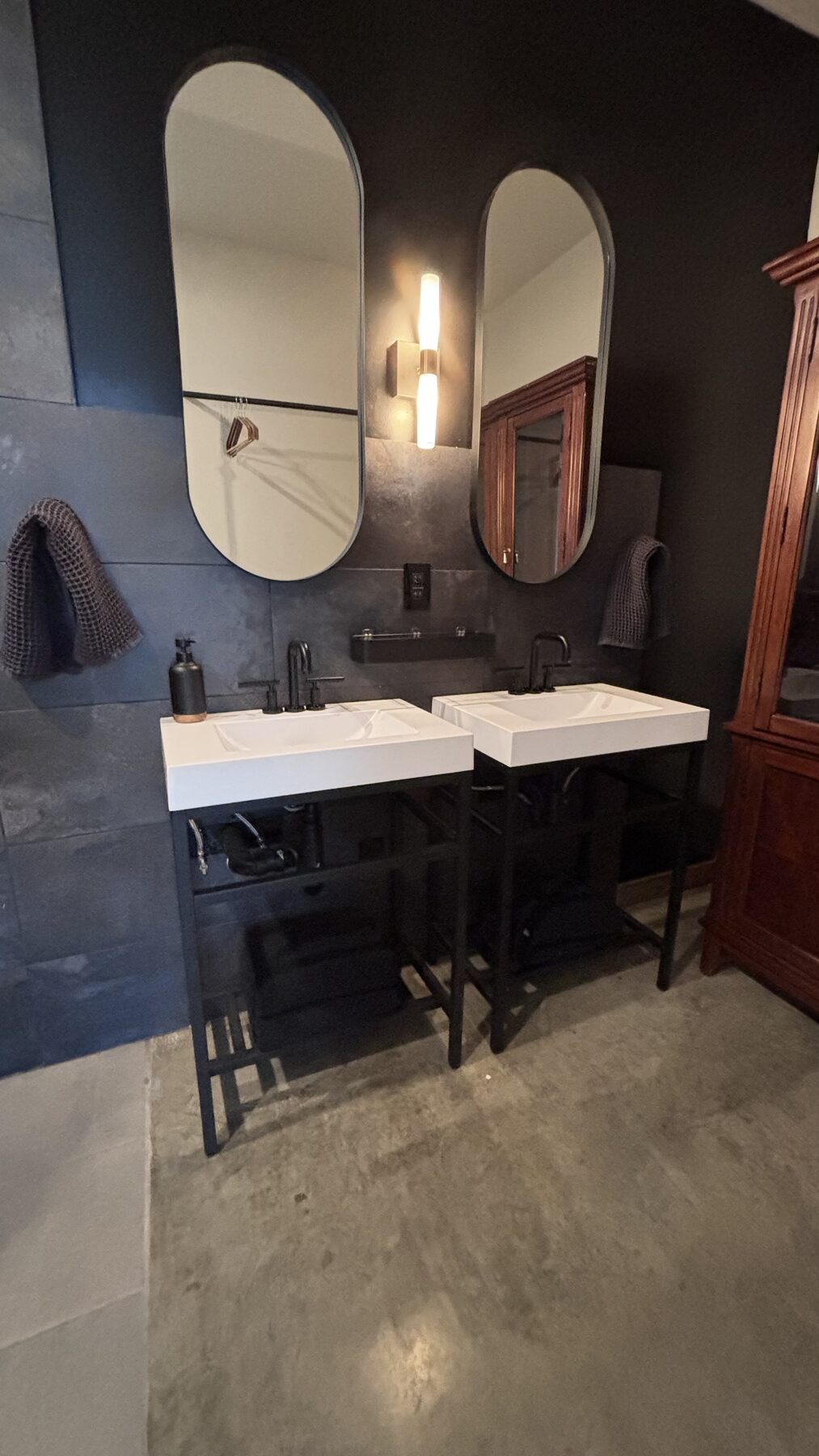 Bathroom with dark tile and a double vanity