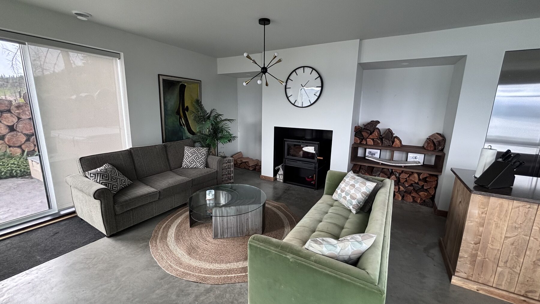 Living room with green sofas and a wood-burning stove